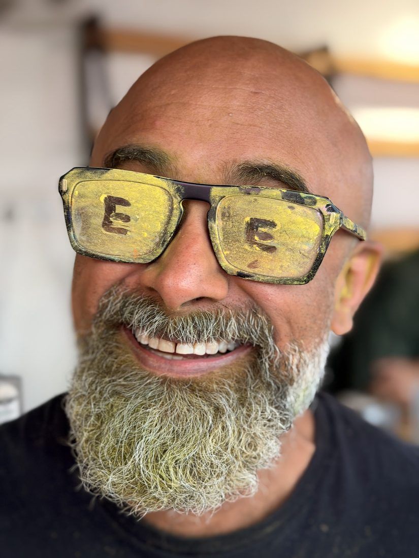 Venky, smiling broadly at the camera in yellow-tinted glasses.